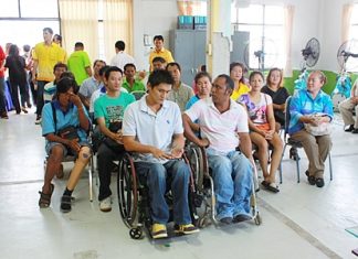 Disabled Chonburi residents listen as Ruangpit Kankulwot lectures on how to make flowers from gossamer and paper.